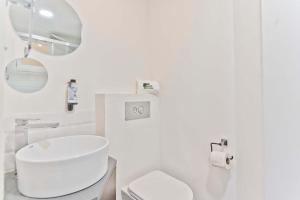 Baño blanco con aseo y lavamanos en BmyGuest - Fado Central Studio, en Lisboa