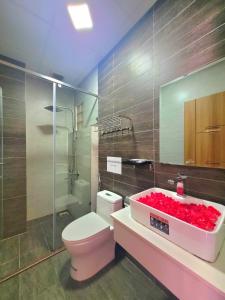 baño con aseo rosa y lavamanos en Dalat Holiday Hotel, en Da Lat