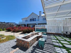 un patio trasero con una hoguera y un edificio en Anchor's Rest, en Yzerfontein