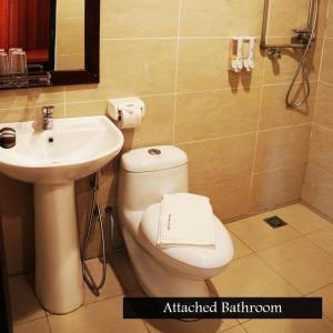 a bathroom with a white toilet and a sink at Kinabatangan Wildlife Lodge in Sandakan