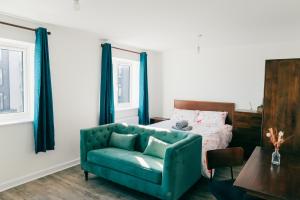 a living room with a green couch and a bed at Oakley Place - Room B Deluxe Double Room in Bristol