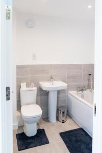 a bathroom with a toilet and a sink and a tub at Oakley Place - Room B Deluxe Double Room in Bristol