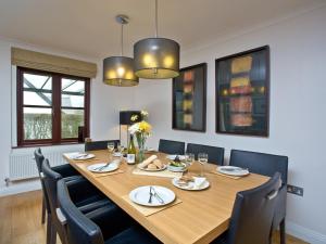 une salle à manger avec une grande table et des chaises en bois dans l'établissement Lily, à Saint Wenn