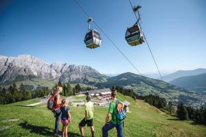 a group of people standing on a hill with a gondola at Wildbach Lodge Dienten in Dienten am Hochkönig