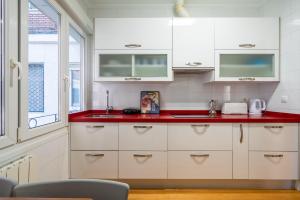 a kitchen with white cabinets and a red counter top at Ybarra apartment by People Rentals in Bilbao