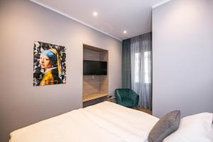 1 dormitorio con cama, espejo y TV en Teatro Suite & Rooms, en Rijeka