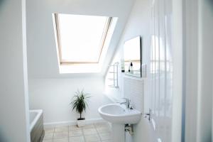 a white bathroom with a sink and a window at 'Hidden Jewel' city centre + FREE PARKING in Plymouth