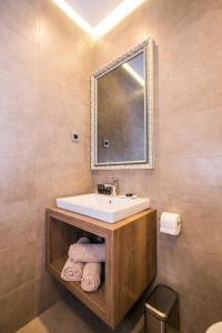 y baño con lavabo, espejo y toallas. en Teatro Suite & Rooms, en Rijeka