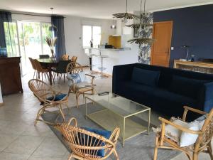 ein Wohnzimmer mit einem blauen Sofa und Stühlen in der Unterkunft MAISON CHAMPAGNE, charmante maison au calme avec beau terrain in Saint-Germain