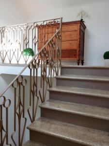 a staircase with a wrought iron railing and a wooden cabinet at CASA PAVONI in Falconara Marittima