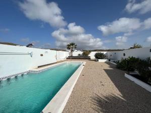 a swimming pool in front of a white building at Loft en zona rural de Lanzarote in Conil