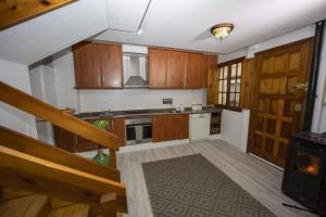 a large kitchen with wooden cabinets and a staircase at Casa Poulo Padrón in Padrón