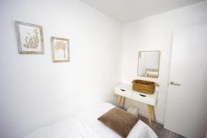 biała sypialnia z łóżkiem i lustrem w obiekcie Casa Poulo Padrón w mieście Padrón