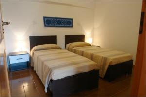 twee bedden in een hotelkamer met bij Primavera Apartments in Capo Testa