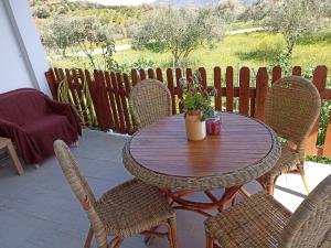 una mesa de madera y sillas en un patio en Chania Mini Villas, en Skinés