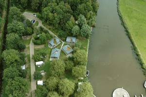 an aerial view of a house next to a river at Camping 't Ol Gat in Zoutkamp