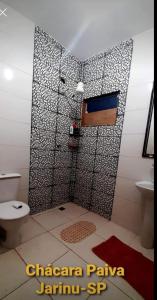 a bathroom with a shower with a toilet and a sink at Chácara Paiva in Jarinu