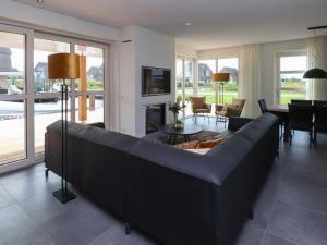 a living room with a large couch and a table at Villa by the Water with Sauna and Terrace in Delfstrahuizen