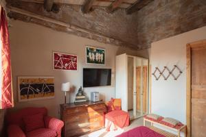 ローマにあるベッド アンド ブレックファスト サンマルティンのリビングルーム(赤い椅子2脚、テレビ付)