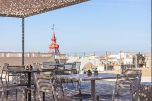 een rij tafels en stoelen op het dak van een restaurant bij Hotel Macià Sevilla Kubb in Sevilla