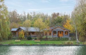 a house sitting on the shore of a body of water at Camping 't Ol Gat in Zoutkamp