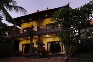 a yellow house with a balcony on the side of it at Alit Bungalow & Warung in Ubud