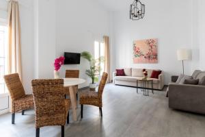 uma sala de estar com uma mesa e cadeiras e um sofá em Casa Palacio Sanlúcar de Barrameda em Sanlúcar de Barrameda