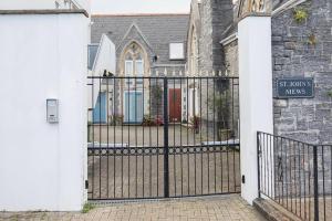 a gate in front of a house with a church at Drakes Nest Plymouth City Centre Location and FREE PARKING in Plymouth