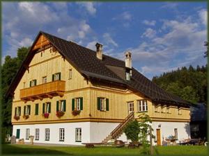 a large wooden house with a black roof at Die Traunmühle in Bad Aussee