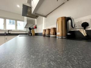 a kitchen with a black counter top in a room at Drakes Nest Plymouth City Centre Location and FREE PARKING in Plymouth