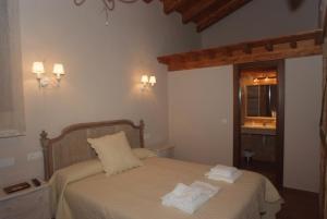 una camera da letto con un letto e asciugamani di La Casona de Doña Petra a Villarmentero de Campos