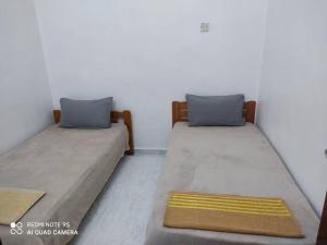 two beds sitting next to each other in a room at R&R HOMESTAY in Simpang Renggam