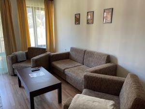 uma sala de estar com dois sofás e uma mesa de centro em Мия 3 Спа хотел Свети Спас em Velingrad