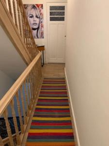 a hallway with a staircase with a colorful striped rug at Huis Agnes in Ostend