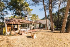 ein weißes Haus mit einer Veranda und Bäumen in der Unterkunft Mas Frederi - Maison avec piscine pour 10 in Paradou