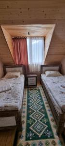 a attic room with two beds and a window at Betegi Guest House in Mestia