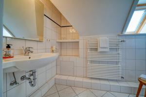 a white bathroom with a sink and a mirror at Hotel Zur Eule in Oldenburg in Holstein