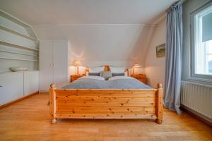 a bedroom with a wooden bed and a window at Hotel Zur Eule in Oldenburg in Holstein