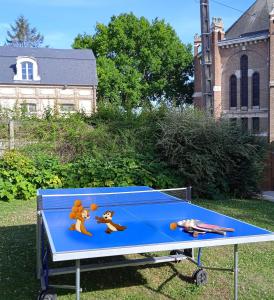 una mesa de ping pong con dos personas jugando en ella en Aux 10 Ponts - Gîte aux abords du fleuve La Somme - La mer à 30 min - La nuit pour 6 voyageurs, en Pont-Rémy