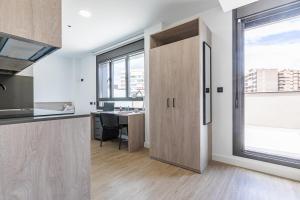 cocina abierta con escritorio y ventana grande en micampus Madrid Sinesio Delgado Student Residence en Madrid