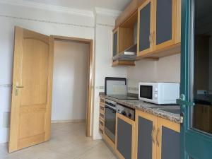 eine Küche mit einer Theke, einer Mikrowelle und einer Tür in der Unterkunft BayView Albufeira in Albufeira