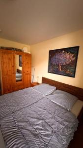 a bedroom with a bed and a painting on the wall at Ferienwohnung am Kormoranweg in Dorum Neufeld