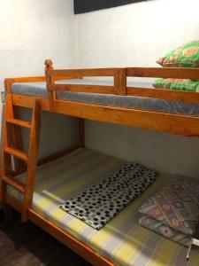 a wooden bunk bed with a cushion on the bottom level at Berly Homestay in Baguio