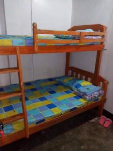 a bunk bed with a blue and yellow checkered floor at Berly Homestay in Baguio