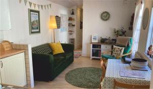 a living room with a green couch and a table at The Sail Loft in Lostwithiel