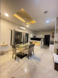 a dining room with a glass table and chairs at Book Rooms & Villa- Bairagarh Living Farm Stay in Shivpurī