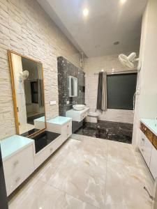 a bathroom with two sinks a toilet and a mirror at Book Rooms & Villa- Bairagarh Living Farm Stay in Shivpurī