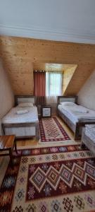 a large room with two beds and a rug at Betegi Guest House in Mestia