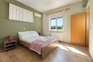 Schlafzimmer mit einem Bett und einem Fenster in der Unterkunft Villa Amelia in Gennadi