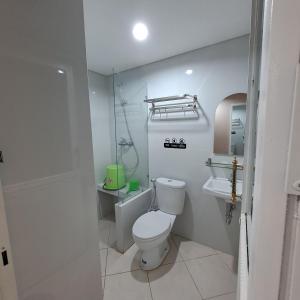 een witte badkamer met een toilet en een wastafel bij Christine Hotel Jogja in Jetis